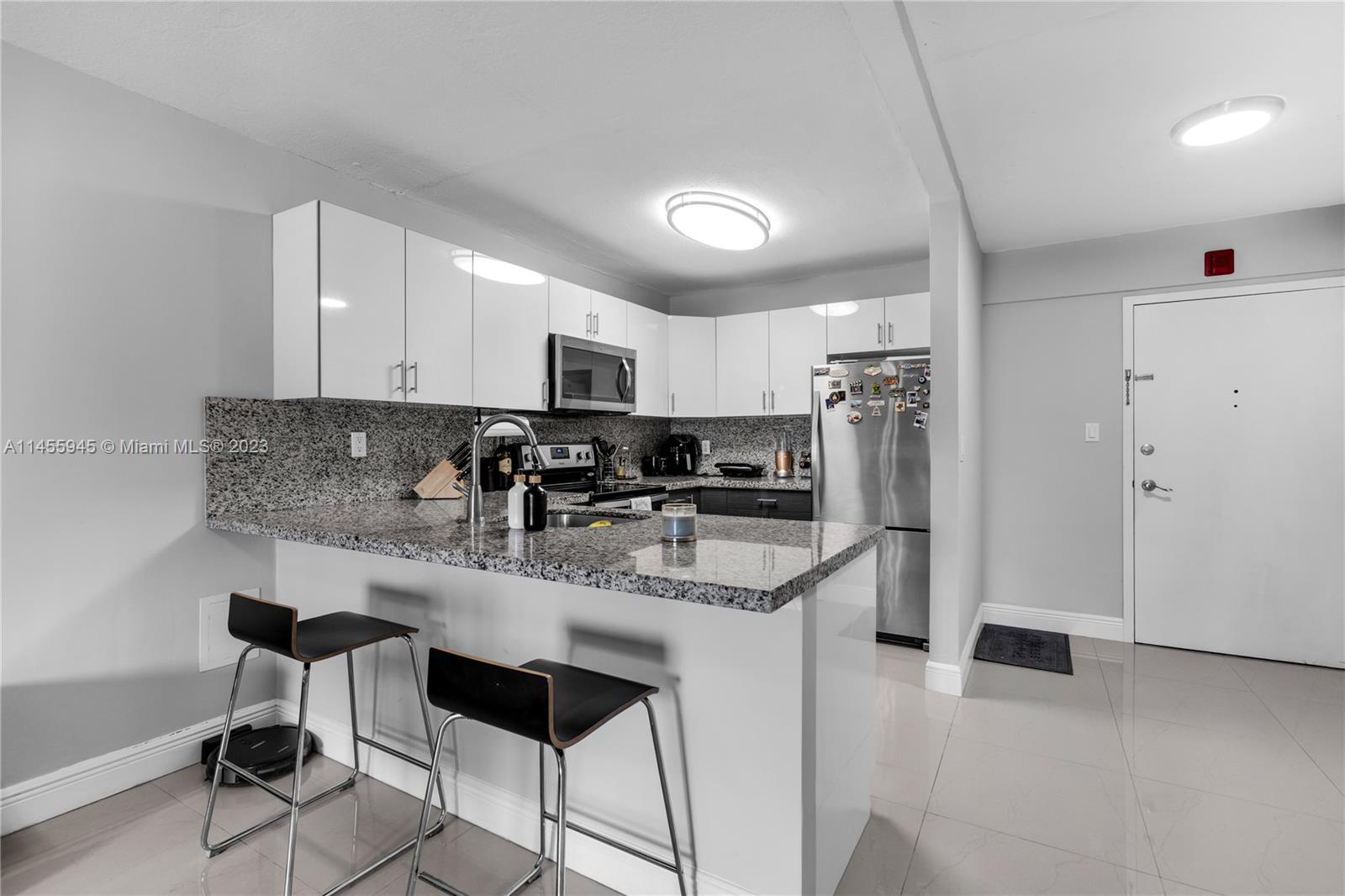 8990 Southwest 24th Street, Unit 15 Miami, FL 33165 - Photo 4 of 21 a kitchen with stainless steel appliances granite countertop a sink a stove a refrigerator cabinets and chairs