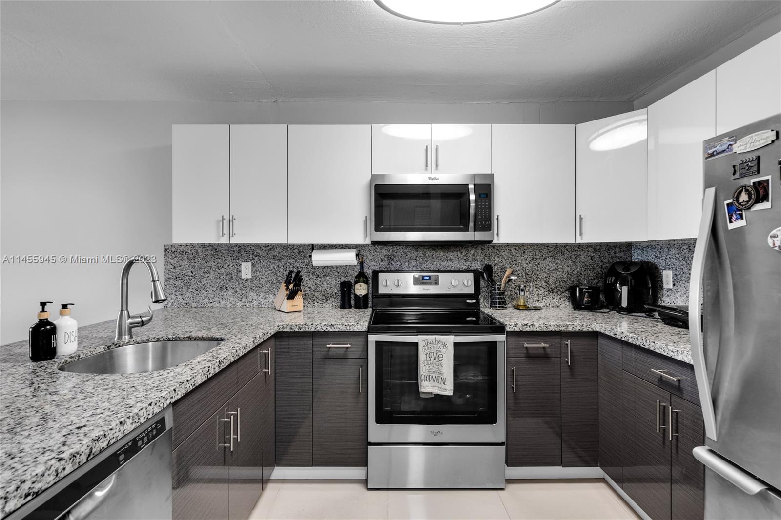 8990 Southwest 24th Street, Unit 15 Miami, FL 33165 - Photo 5 of 21 a kitchen with stainless steel appliances granite countertop a sink stove microwave and refrigerator