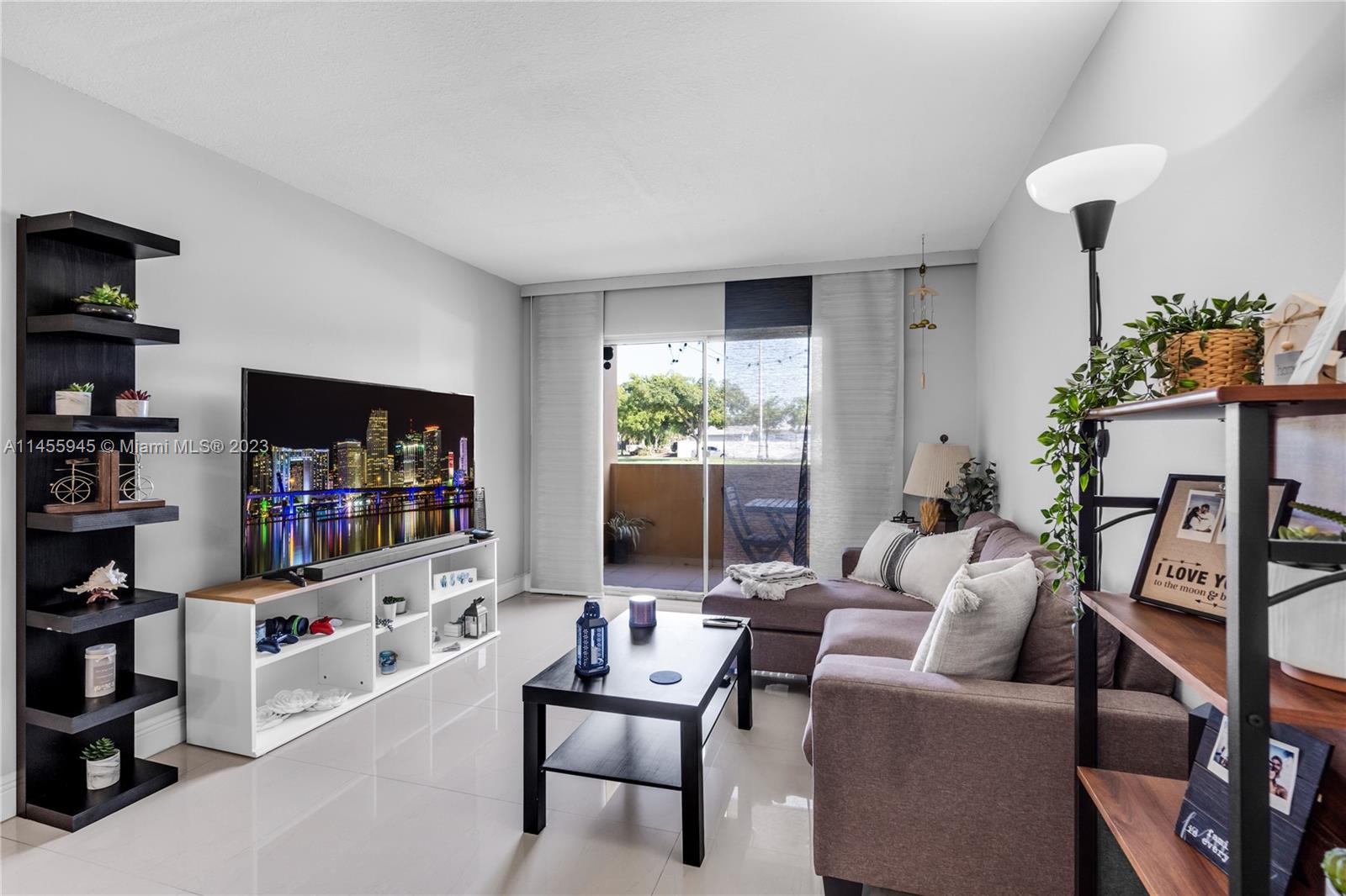 8990 Southwest 24th Street, Unit 15 Miami, FL 33165 - Photo 7 of 21 a living room with furniture and a flat screen tv