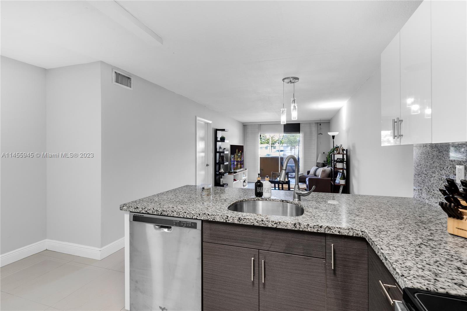 8990 Southwest 24th Street, Unit 15 Miami, FL 33165 - Photo 9 of 21 a kitchen with granite countertop kitchen island a sink stove and cabinets