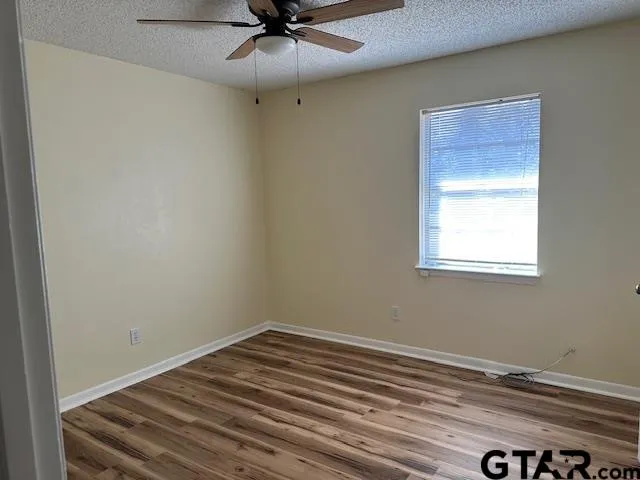 a view of a room with a ceiling fan and a window