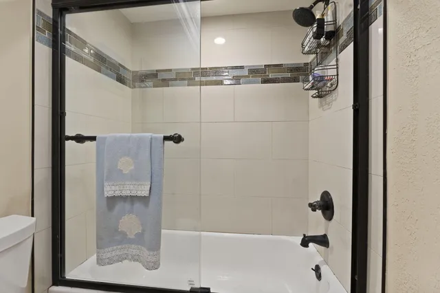 a bedroom with a bed and a large window with kitchen view