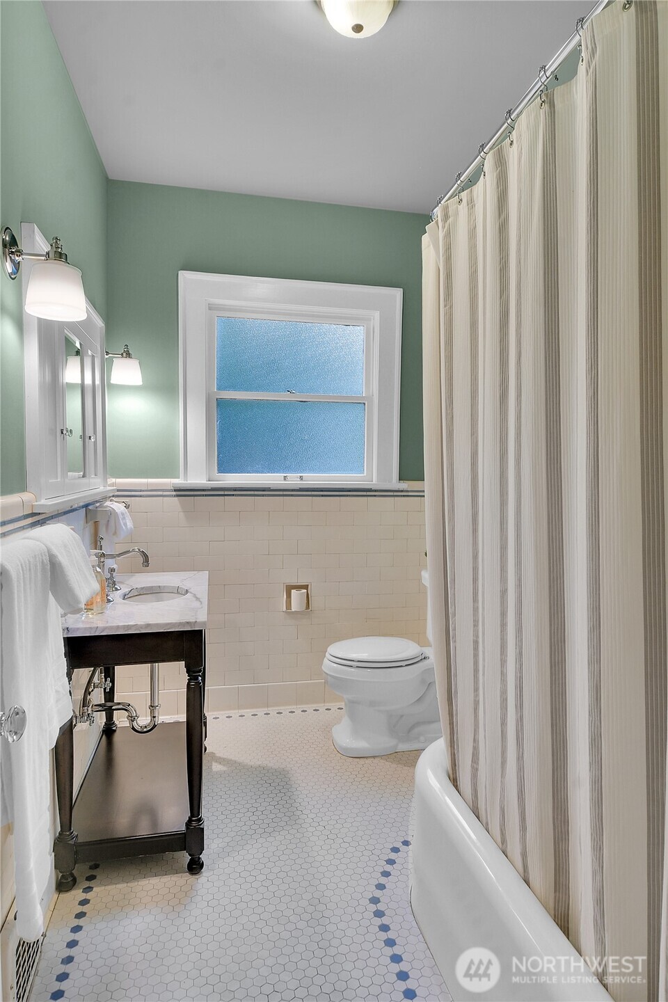 110 Smith Street Seattle, WA 98109 - Photo 15 of 35 a bathroom with a toilet a sink and mirror
