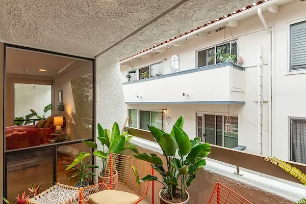 a living room with furniture potted plant and windows