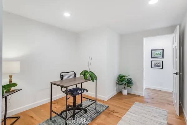 a view of a workspace room with furniture and wooden floor