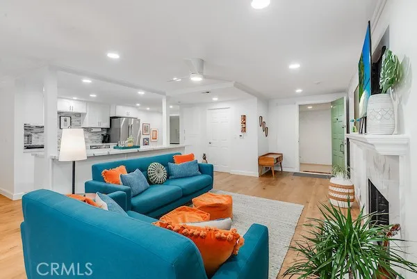 a living room with furniture and a fireplace with wooden floor