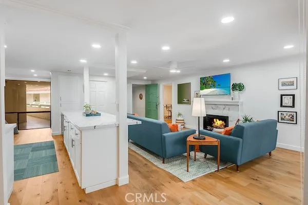 a living room with furniture a fireplace and a kitchen view