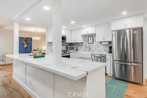a kitchen with stainless steel appliances a refrigerator sink and microwave