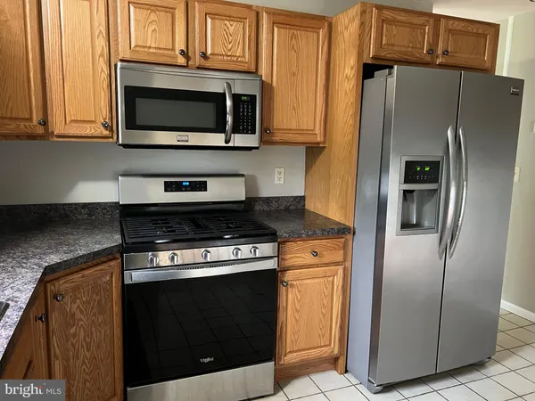 a kitchen with stainless steel appliances granite countertop a refrigerator stove and microwave