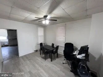 a view of a workspace with furniture and a ceiling fan