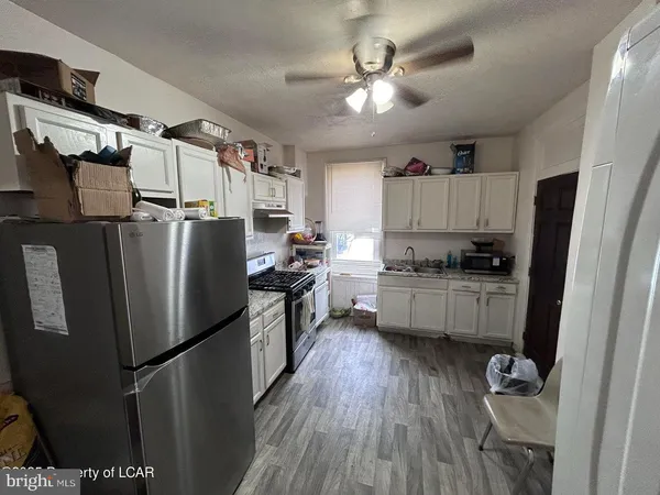 a kitchen with stainless steel appliances a refrigerator a sink a stove a microwave and cabinets