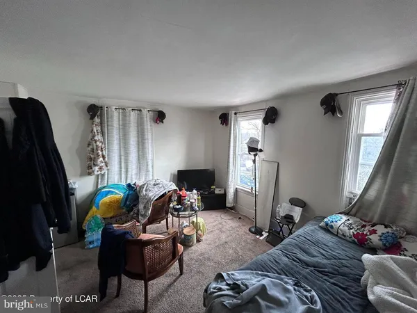 a living room with furniture chess board and a flat screen tv