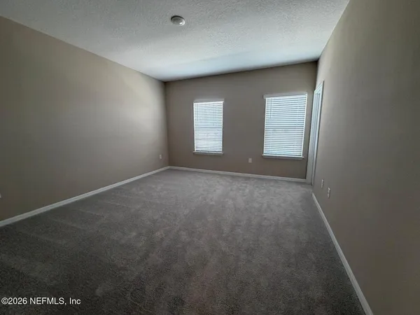 a white toilet sitting next to a white wall