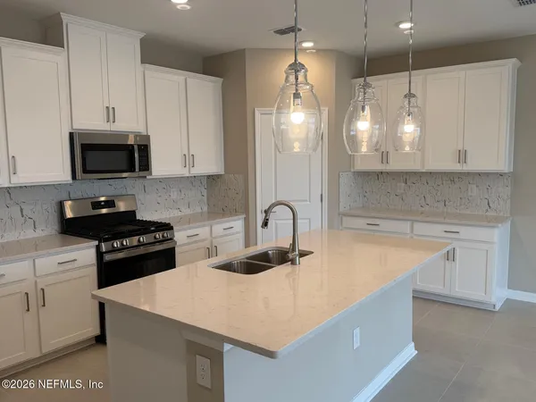 a kitchen with a sink a stove a microwave and cabinets