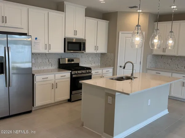 a kitchen with a sink a stove a refrigerator and cabinets