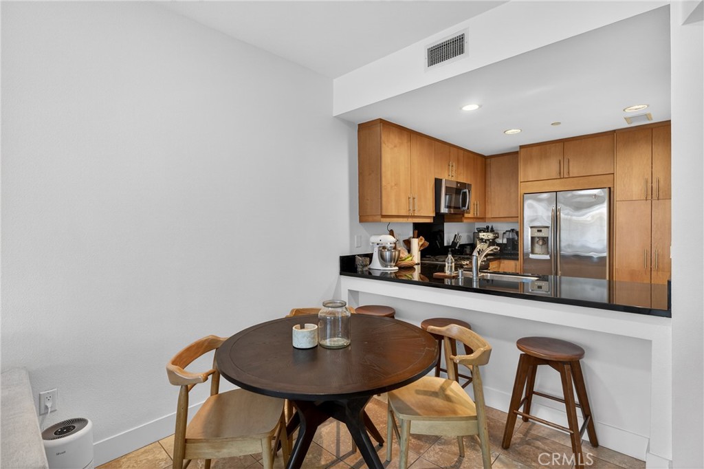 150 The Promenade North, Unit 415 Long Beach, CA 90802 - Photo 12 of 46 a kitchen with stainless steel appliances granite countertop a sink a microwave cabinets and chairs