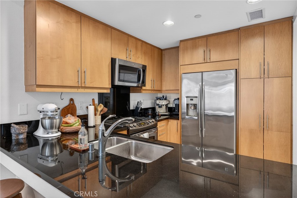 150 The Promenade North, Unit 415 Long Beach, CA 90802 - Photo 17 of 46 a kitchen with refrigerator and cabinets