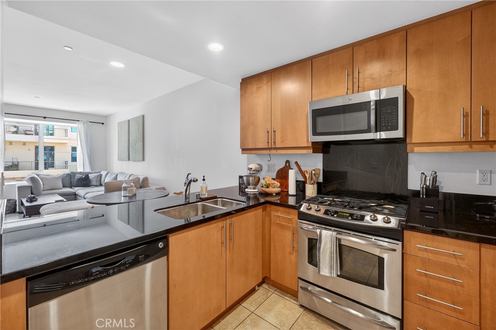 150 The Promenade North, Unit 415 Long Beach, CA 90802 - Photo 18 of 46 a kitchen with granite countertop a sink cabinets and stainless steel appliances