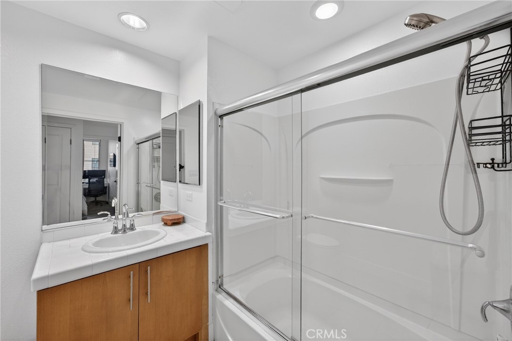 150 The Promenade North, Unit 415 Long Beach, CA 90802 - Photo 22 of 46 a bathroom with a granite countertop sink a mirror and a shower