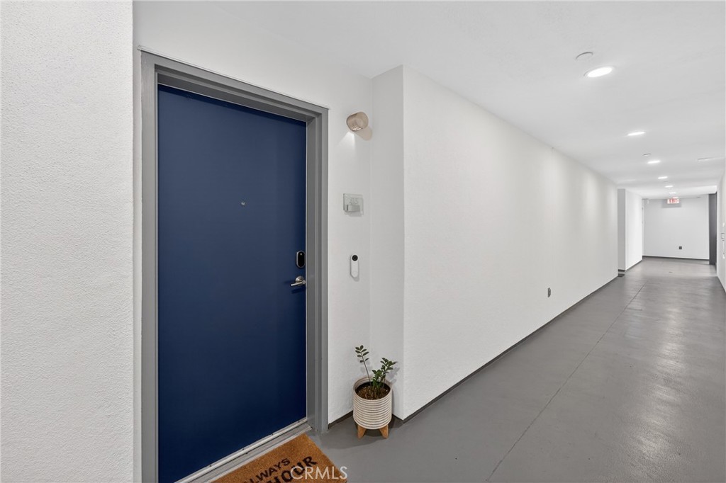 150 The Promenade North, Unit 415 Long Beach, CA 90802 - Photo 3 of 46 a view of a hallway with wooden floor and a bathroom