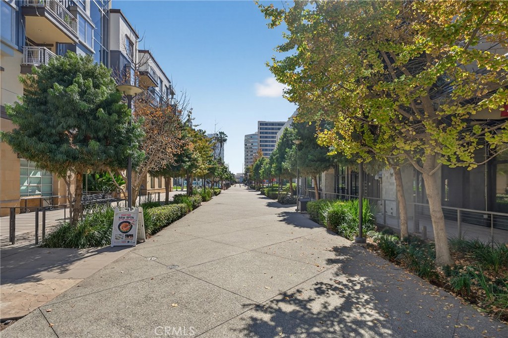 150 The Promenade North, Unit 415 Long Beach, CA 90802 - Photo 41 of 46 a wooden bench with view of trees and buildings in the background