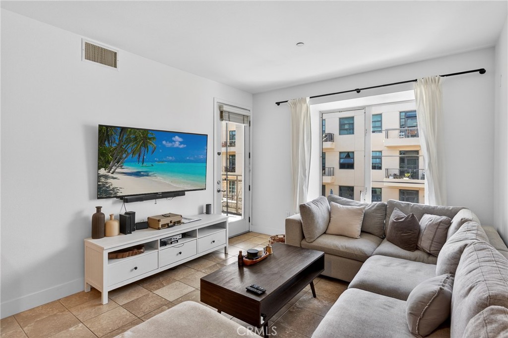 150 The Promenade North, Unit 415 Long Beach, CA 90802 - Photo 7 of 46 a living room with furniture and a flat screen tv