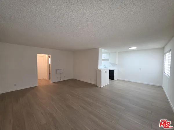 an empty room with wooden floor and window