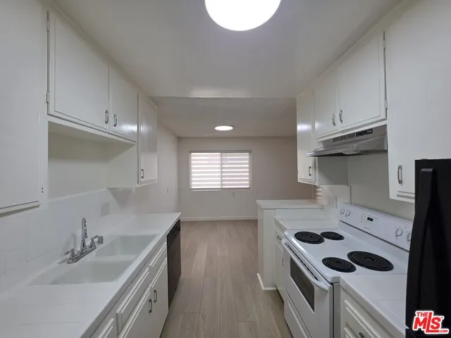 a kitchen with a sink stove top oven and cabinets