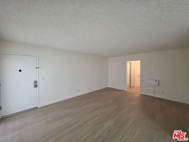 a view of an empty room and wooden floor