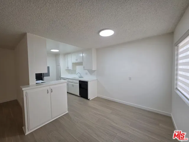 a kitchen with a sink cabinets and wooden floor