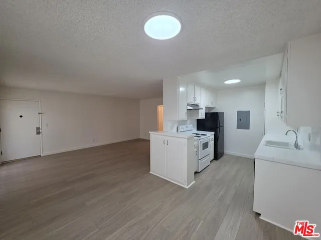 a kitchen with cabinets wooden floor and a sink