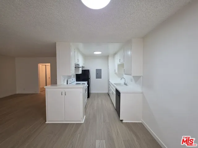 a kitchen with wooden floor and a sink