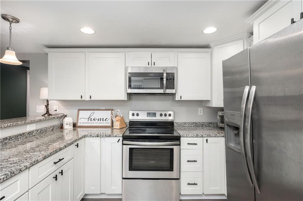 100 Blom Road Grove City, PA 16127 - Photo 17 of 31 a kitchen with stainless steel appliances granite countertop a stove a refrigerator and a white cabinets
