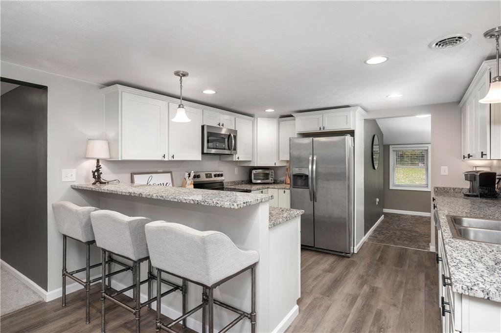 100 Blom Road Grove City, PA 16127 - Photo 9 of 31 a kitchen with stainless steel appliances granite countertop a refrigerator a stove a sink a dining table and chairs