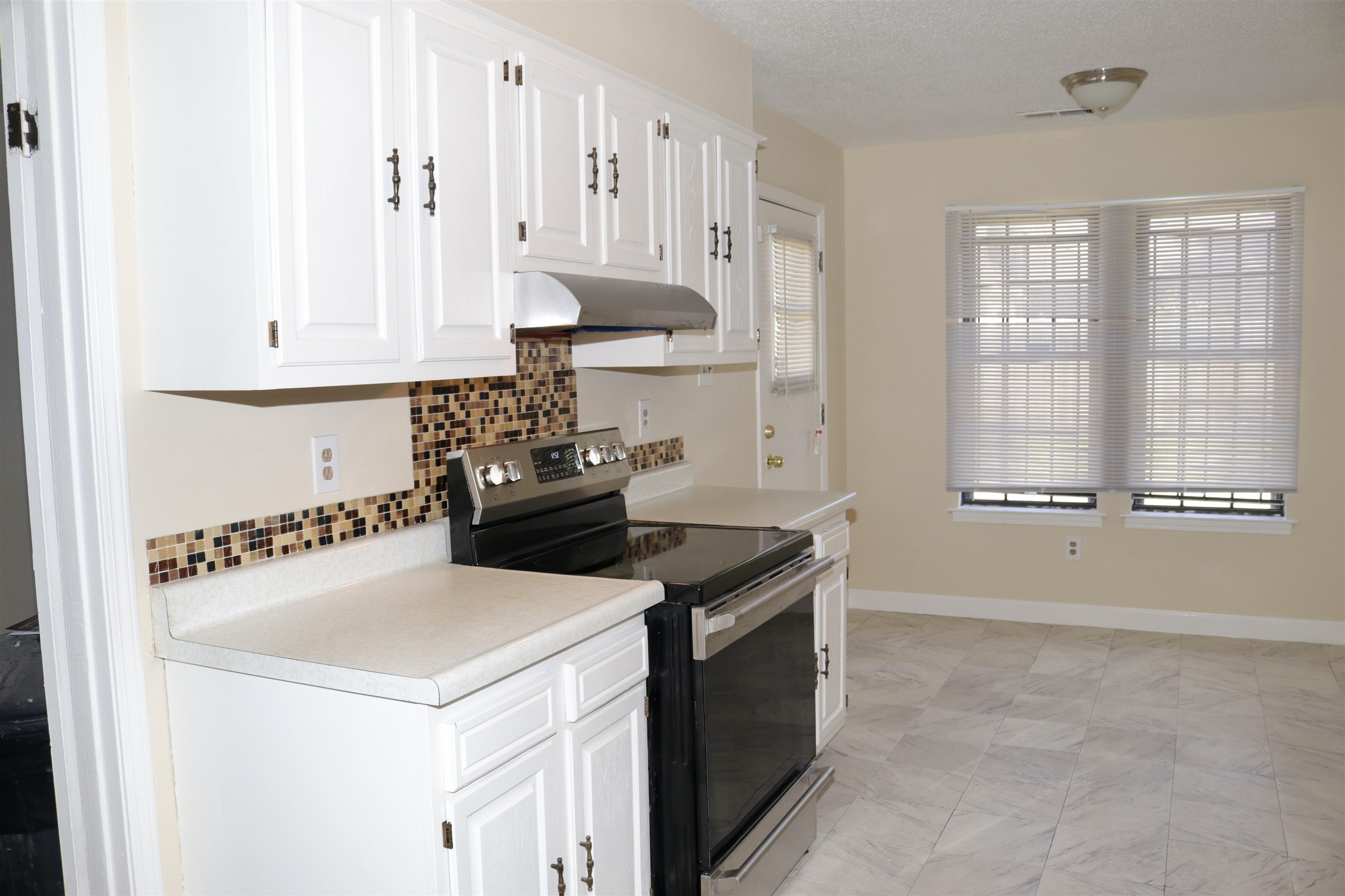4418 Spring Park Drive Memphis, TN 38141 - Photo 11 of 12 a kitchen with stainless steel appliances a stove a white cabinet and a refrigerator