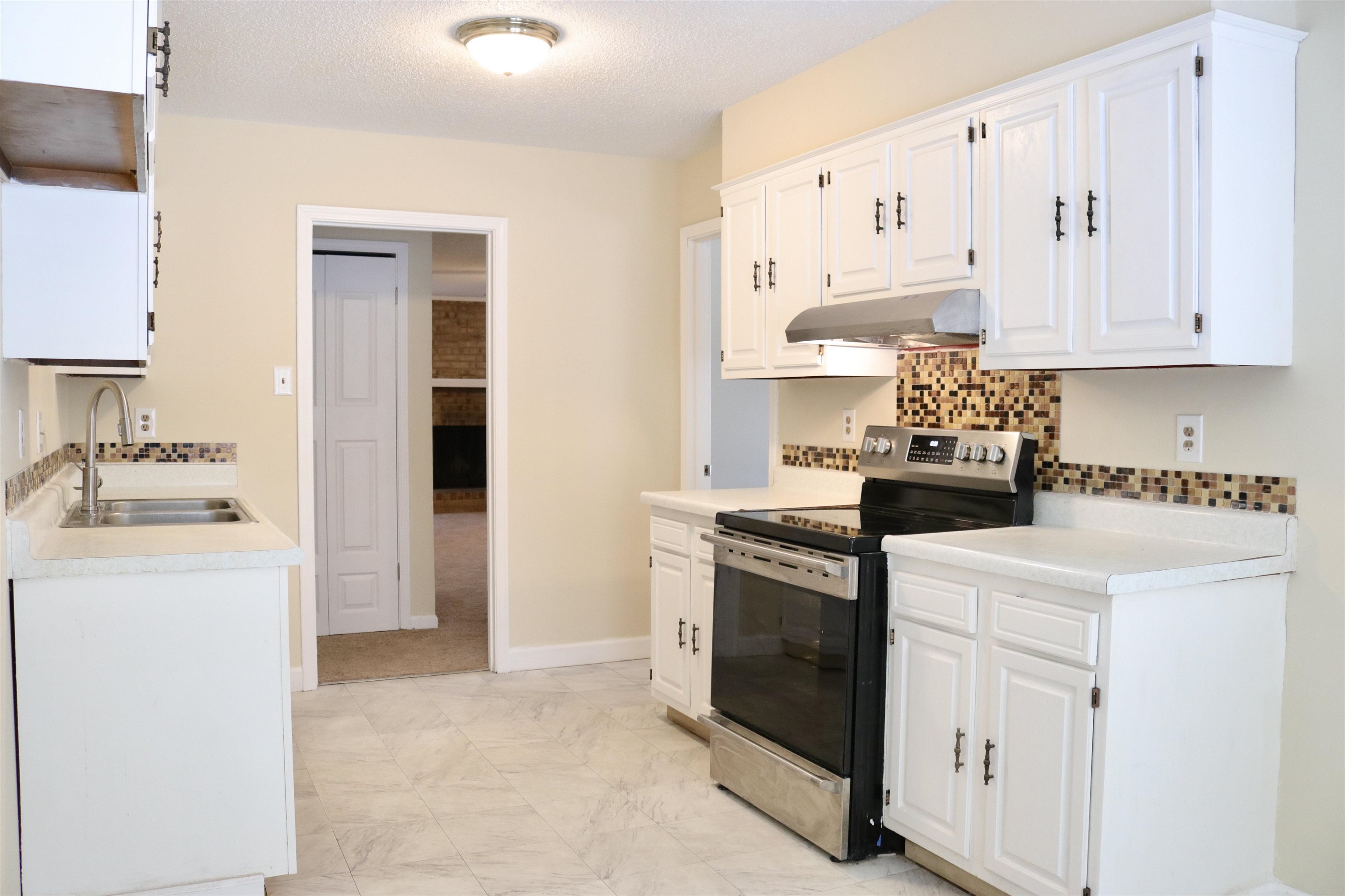 4418 Spring Park Drive Memphis, TN 38141 - Photo 3 of 12 a kitchen with granite countertop white cabinets and white appliances