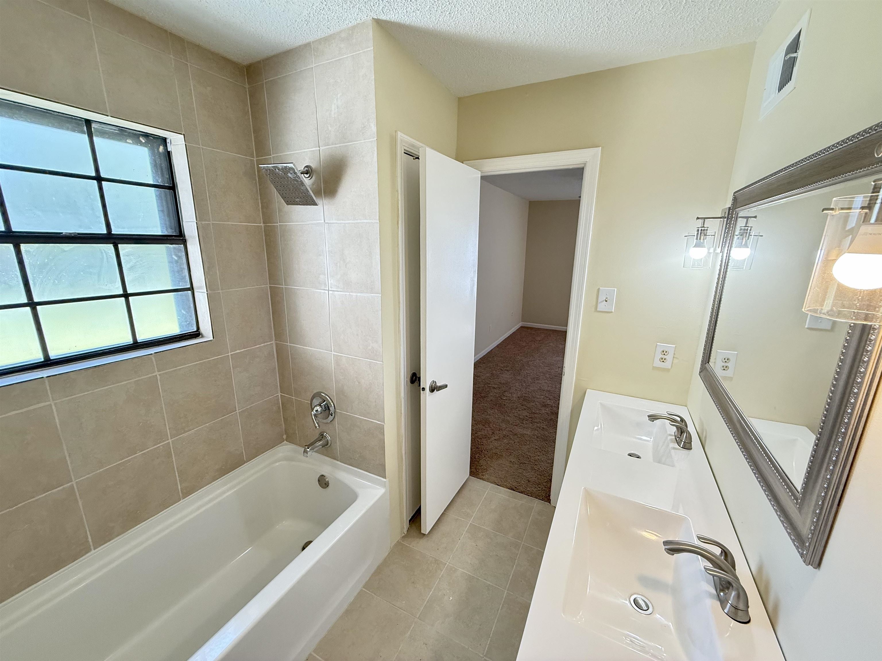 4418 Spring Park Drive Memphis, TN 38141 - Photo 7 of 12 a bathroom with a tub a sink and a large mirror