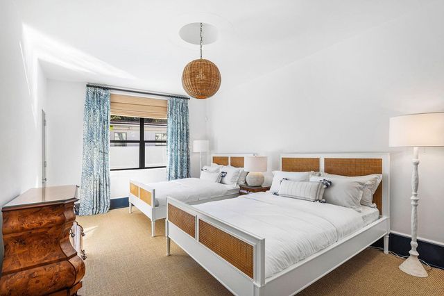 a bed room with two bed and a window