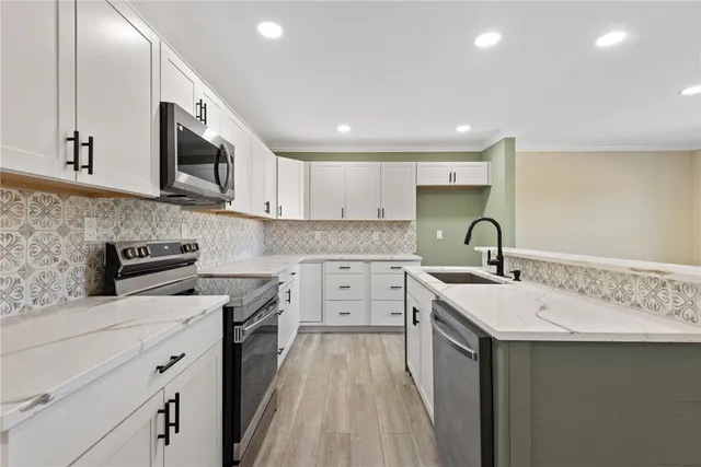 a kitchen with a sink stove cabinets and entryway