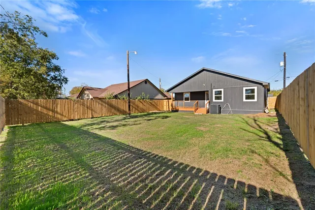 a view of a house with backyard and tree