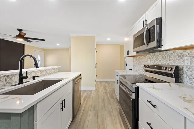 a kitchen with stainless steel appliances granite countertop a sink and stove top oven