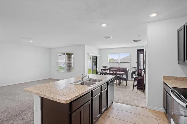 a open kitchen with stainless steel appliances granite countertop a stove and a sink