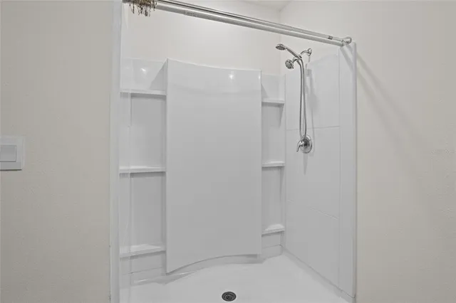 a bathroom with a shower and a glass door