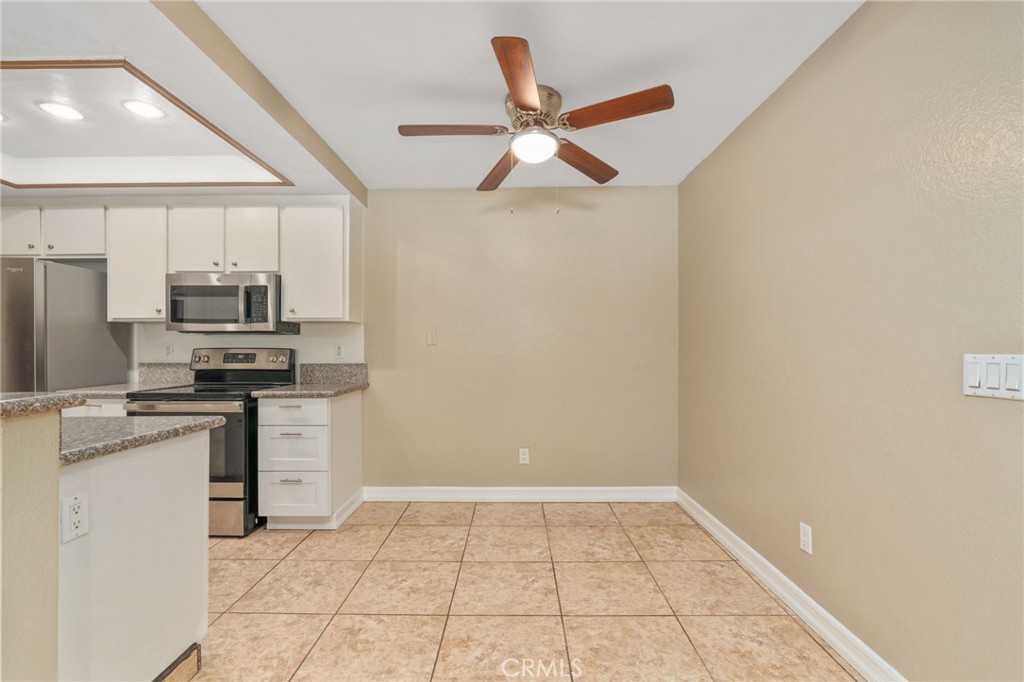 3535 Banbury Drive, Unit 119 Riverside, CA 92505 - Photo 7 of 23 a kitchen with a refrigerator and white cabinets