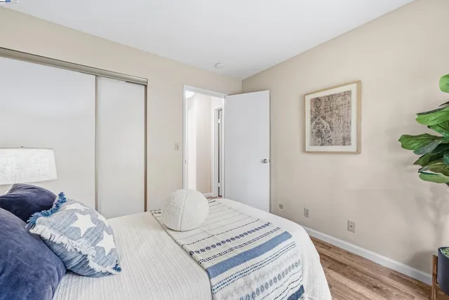 a bedroom with a bed and a lamp on table next to a window