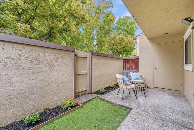 a view of a chair and table in backyard of the house