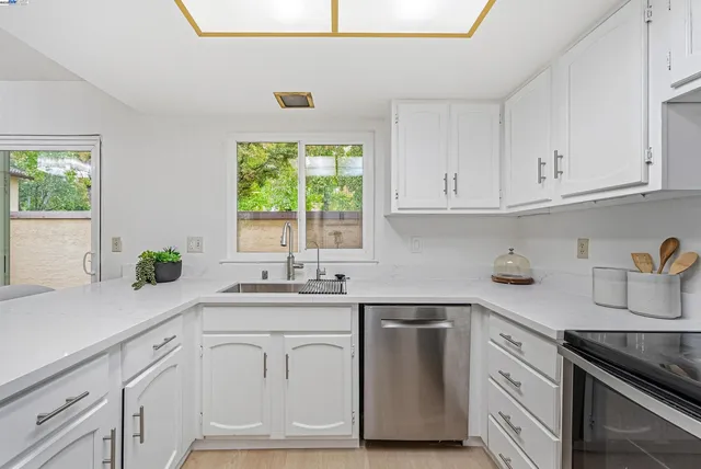 a kitchen with granite countertop white cabinets and a window