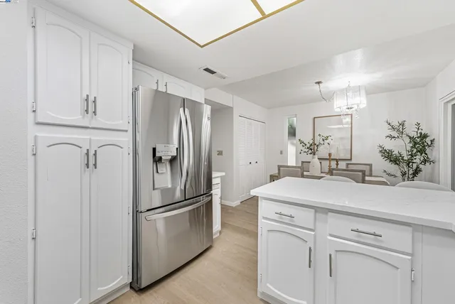 a kitchen with white cabinets and stainless steel appliances