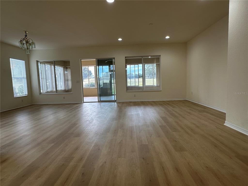 12900 Southeast 97th Terrace Road Summerfield, FL 34491 - Photo 8 of 28 an empty room with wooden floor and windows