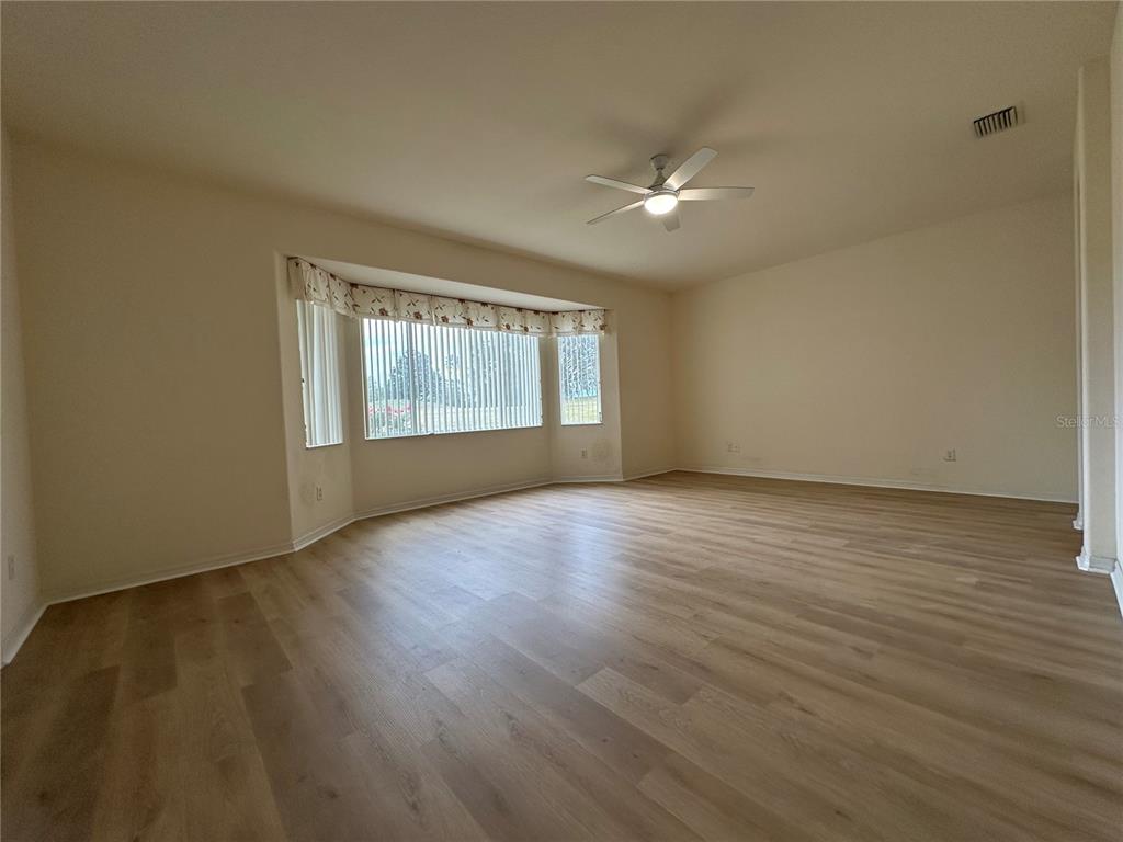12900 Southeast 97th Terrace Road Summerfield, FL 34491 - Photo 10 of 28 a view of an empty room with wooden floor and a window